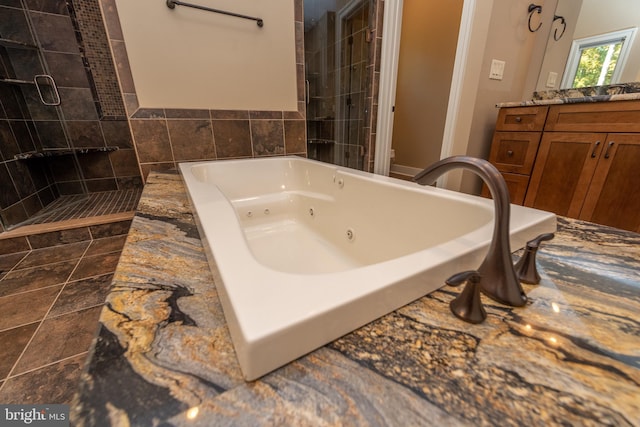 bathroom with tile flooring, vanity, and shower with separate bathtub