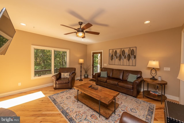 living room with light hardwood / wood-style flooring and ceiling fan