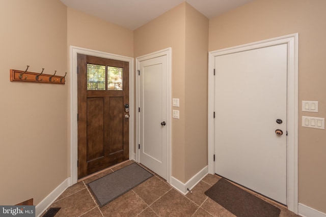 foyer featuring dark tile flooring