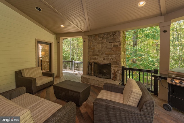 view of patio / terrace with a wooden deck and an outdoor living space with a fireplace