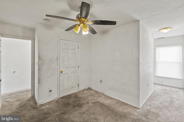 carpeted spare room with ceiling fan