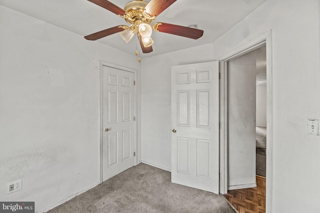 unfurnished bedroom featuring a closet, ceiling fan, and dark carpet