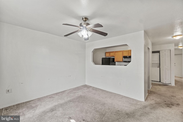 carpeted empty room featuring ceiling fan and washer / clothes dryer