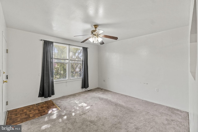 carpeted spare room featuring ceiling fan