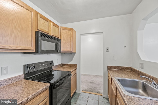 kitchen with light brown cabinets, black appliances, sink, light tile floors, and dark stone counters