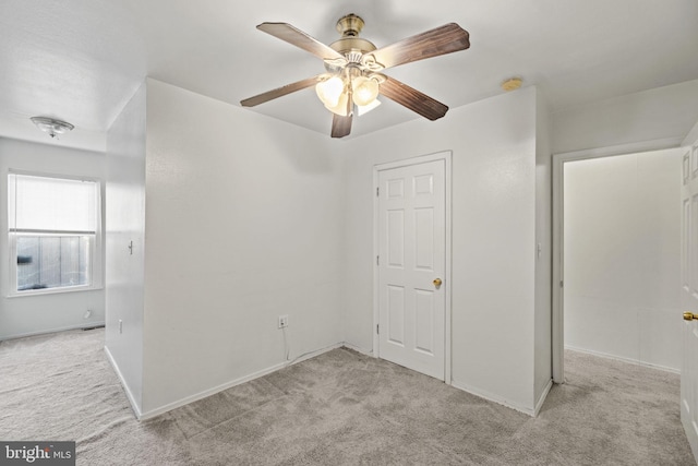 carpeted spare room featuring ceiling fan