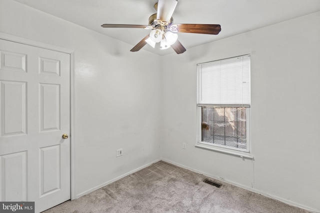 carpeted spare room featuring ceiling fan