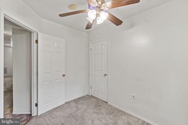 unfurnished bedroom featuring light carpet and ceiling fan