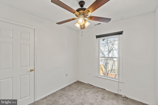 carpeted spare room with ceiling fan