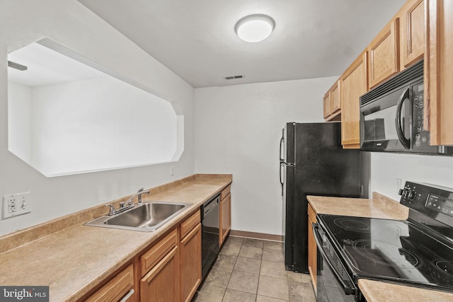 kitchen with sink, light tile floors, and black appliances