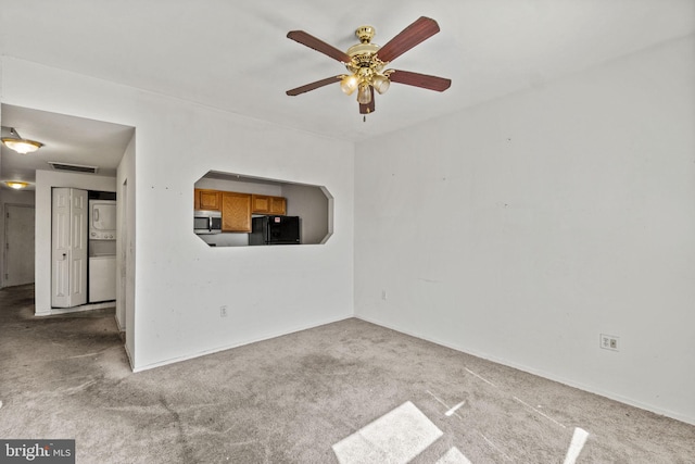 unfurnished living room with carpet floors, ceiling fan, and stacked washing maching and dryer