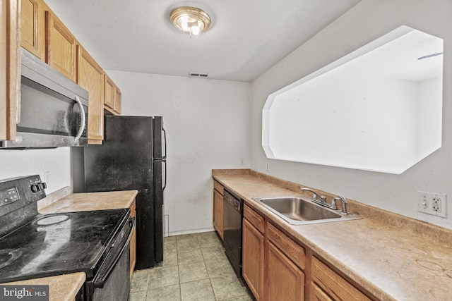 kitchen with sink, black appliances, and light tile floors