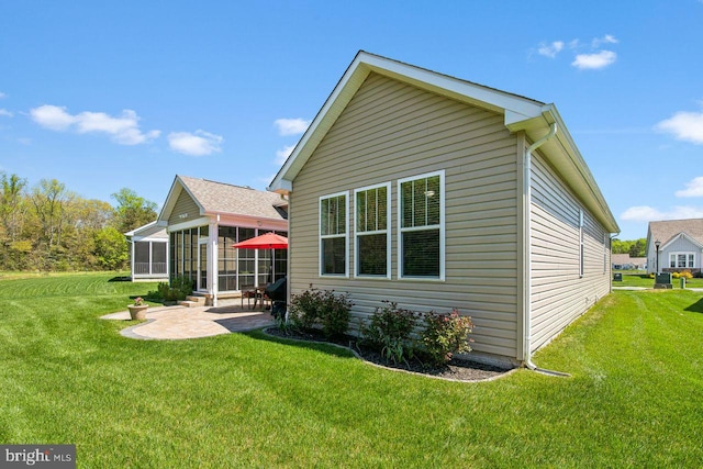 rear view of house with a patio area, a yard, and a sunroom