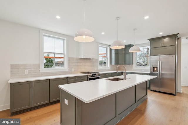 kitchen featuring a sink, light countertops, stainless steel appliances, light wood-type flooring, and custom exhaust hood