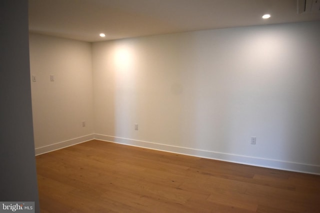 empty room with baseboards, recessed lighting, and wood finished floors