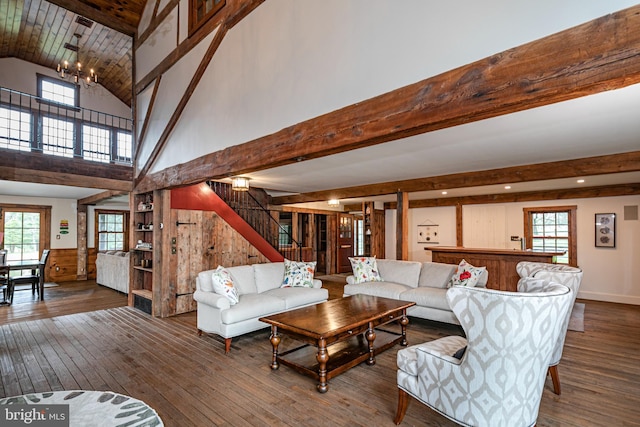 living room featuring hardwood / wood-style floors, a notable chandelier, beamed ceiling, and high vaulted ceiling