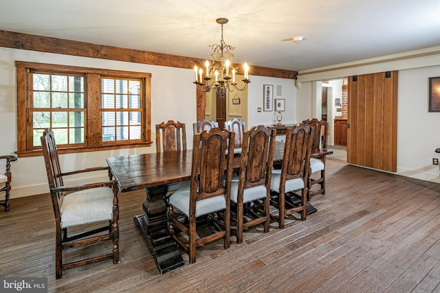 dining area with hardwood / wood-style floors and a chandelier