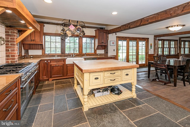 kitchen with wooden counters, sink, plenty of natural light, and range with two ovens