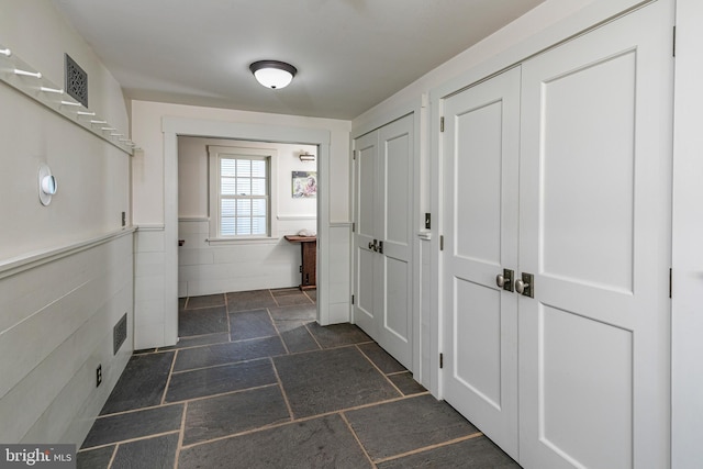 hall featuring dark tile flooring