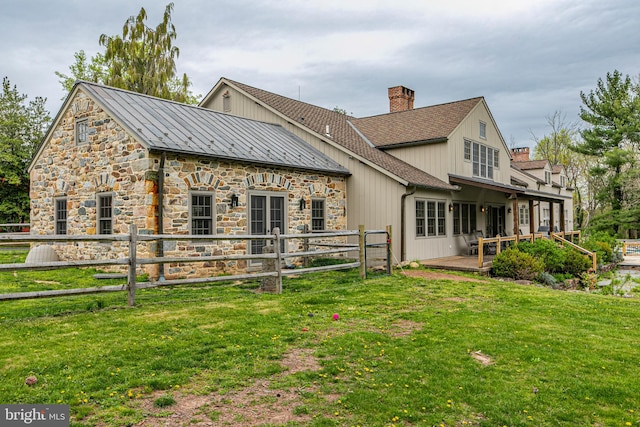 rear view of property featuring a lawn