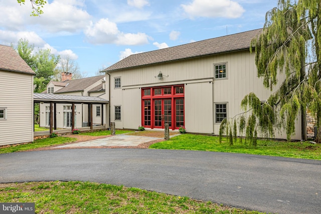 view of front facade with french doors and a front lawn