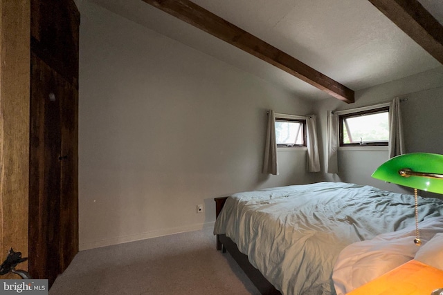 carpeted bedroom with vaulted ceiling with beams