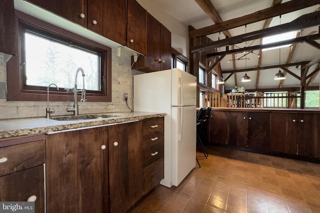 kitchen with white refrigerator, sink, a healthy amount of sunlight, and pendant lighting