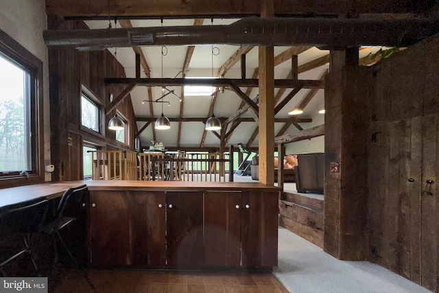 kitchen featuring vaulted ceiling with beams and carpet flooring