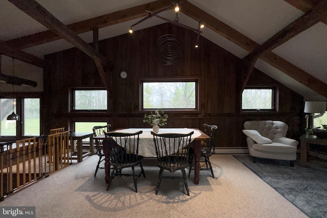 dining room with high vaulted ceiling, a baseboard heating unit, beam ceiling, carpet flooring, and wooden walls