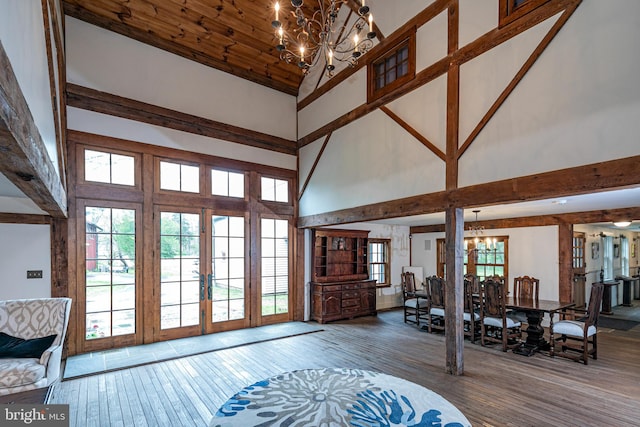 foyer with high vaulted ceiling, a notable chandelier, hardwood / wood-style flooring, and french doors