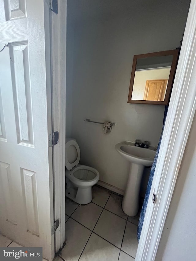 bathroom featuring toilet and tile floors