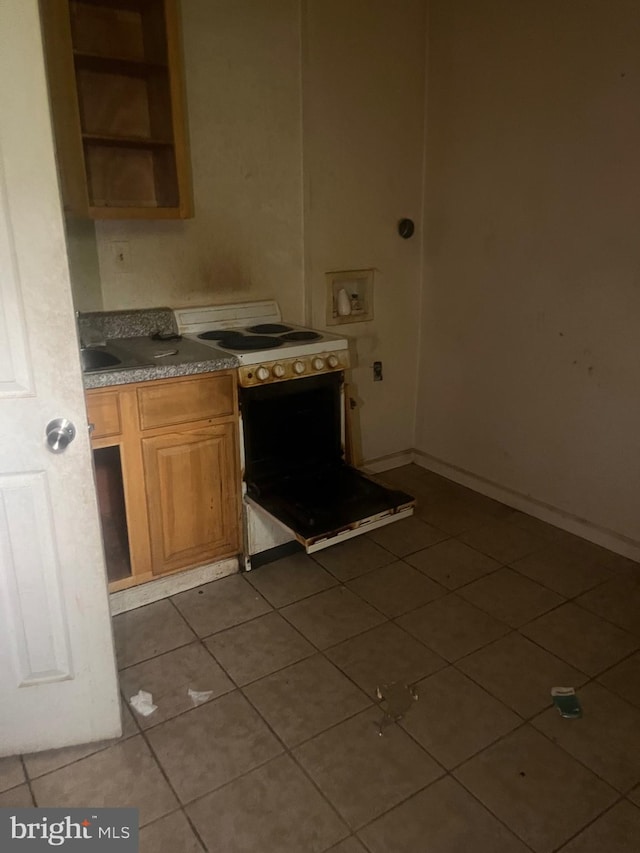 kitchen featuring electric stove and light tile flooring