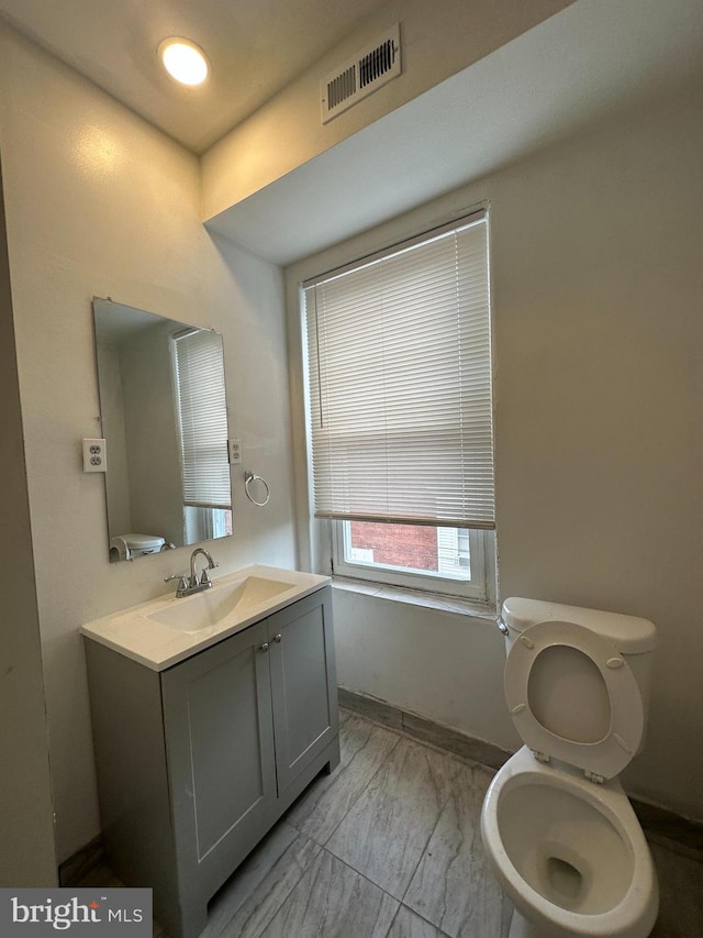 bathroom featuring vanity, tile floors, and toilet