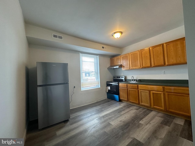 kitchen featuring appliances with stainless steel finishes, sink, and dark hardwood / wood-style flooring