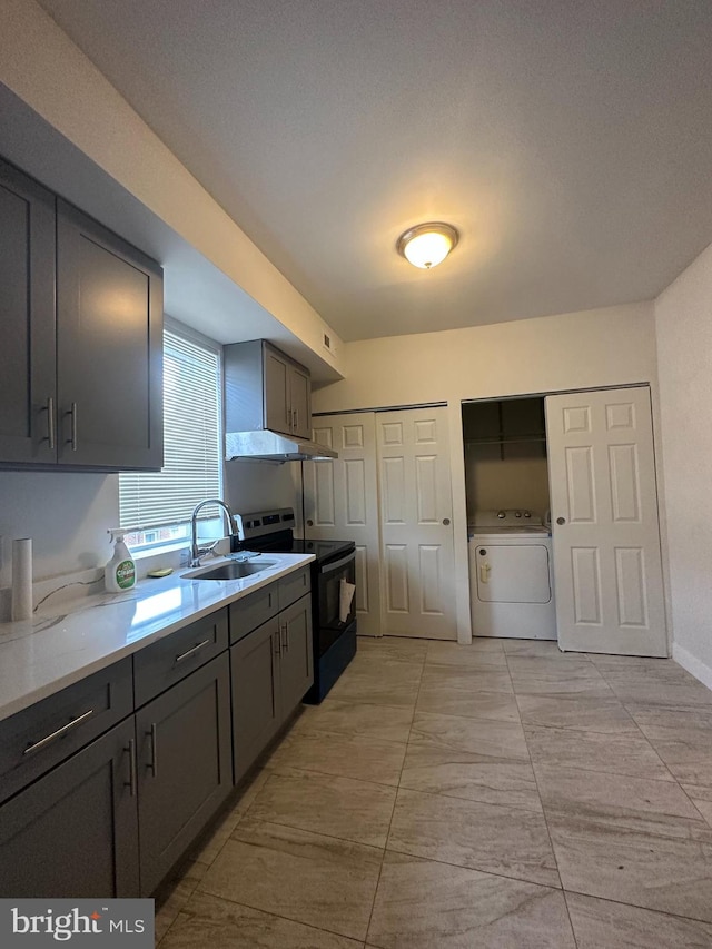 kitchen featuring light tile floors, washing machine and clothes dryer, sink, gray cabinetry, and range with electric stovetop