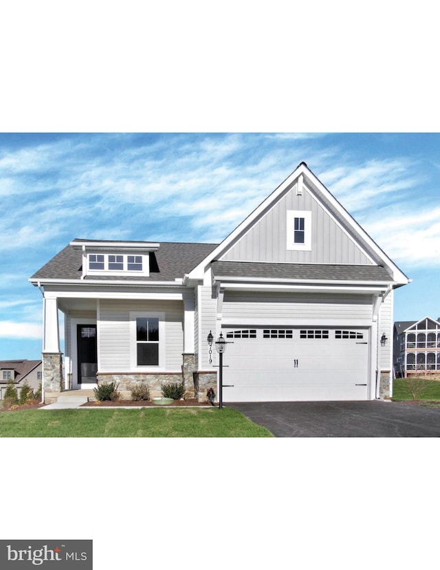 craftsman inspired home featuring a front yard, a porch, and a garage