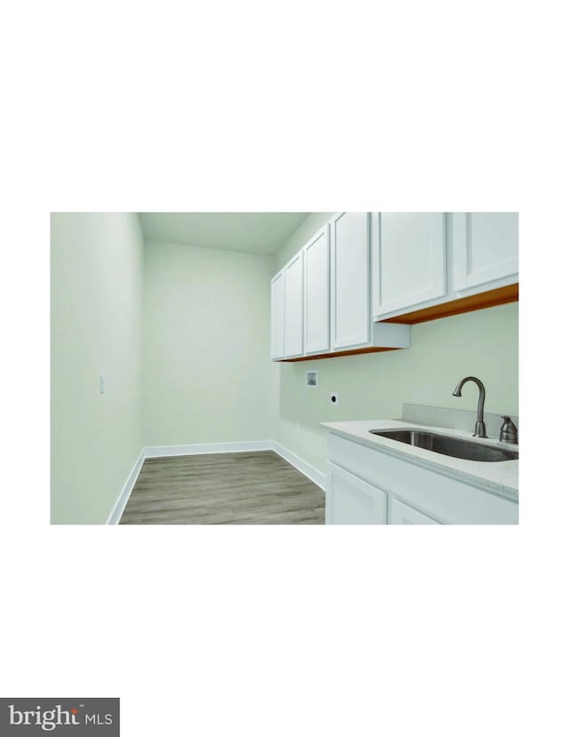 laundry room with light hardwood / wood-style flooring, hookup for an electric dryer, cabinets, and sink