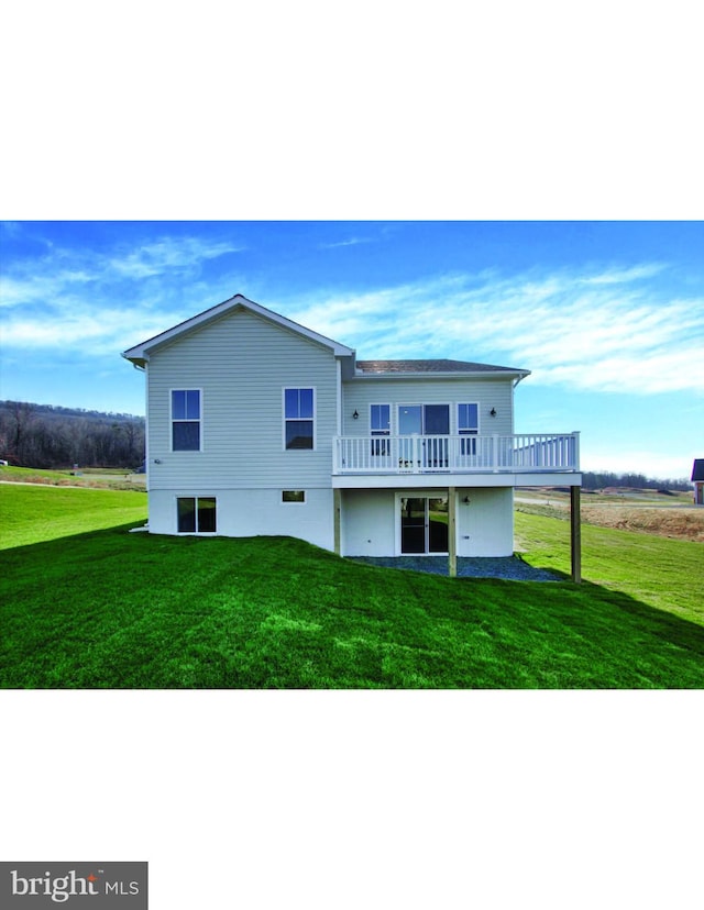 rear view of property with a yard and a wooden deck