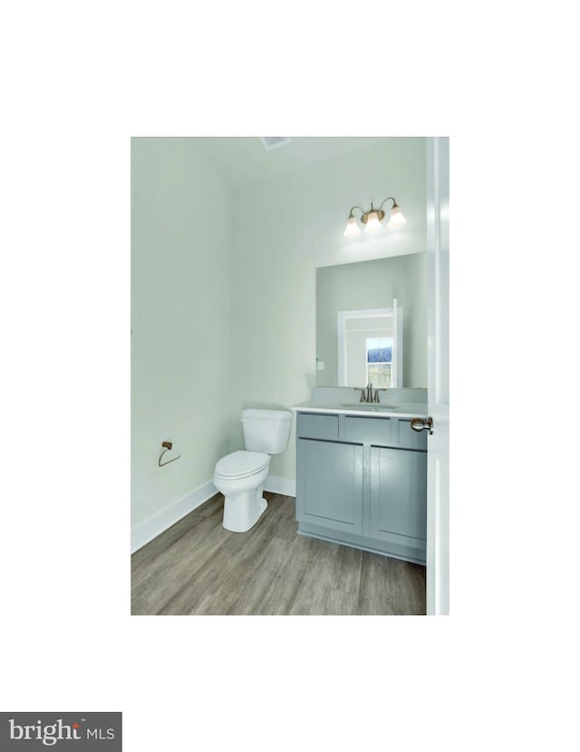 bathroom with wood-type flooring, toilet, and vanity