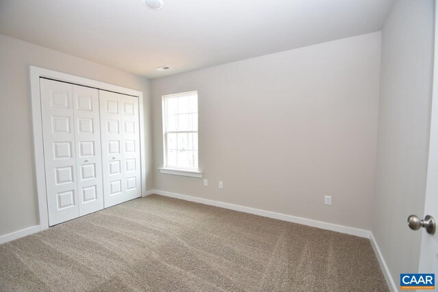 unfurnished bedroom with carpet and a closet