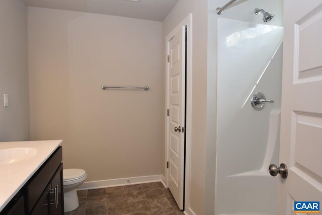 bathroom with toilet, vanity, walk in shower, and tile patterned floors