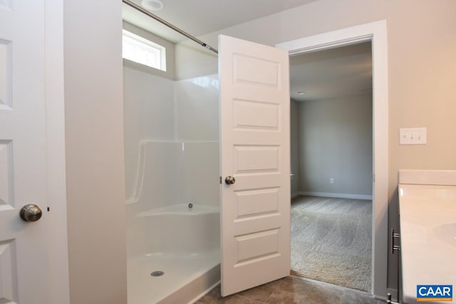 bathroom with tile patterned flooring, a shower, and vanity