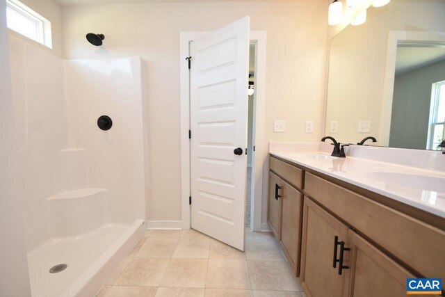 bathroom featuring tile patterned flooring, vanity, and walk in shower