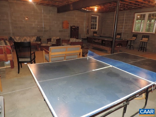 playroom featuring concrete floors and beamed ceiling