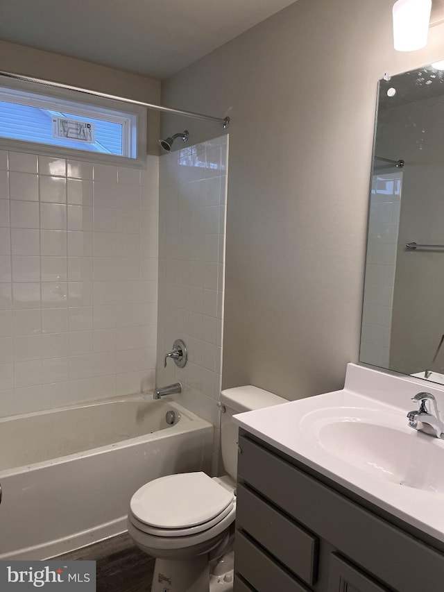 full bathroom with wood-type flooring, vanity, toilet, and tiled shower / bath combo