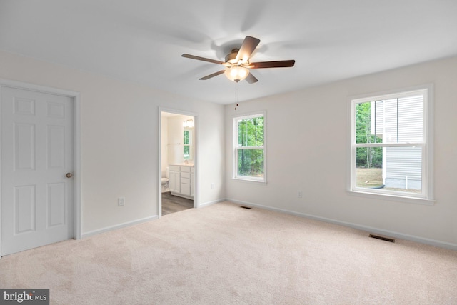 empty room with a healthy amount of sunlight, carpet floors, and ceiling fan