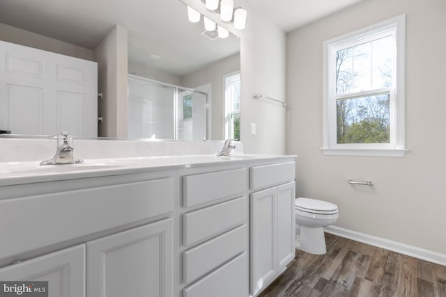 bathroom featuring dual bowl vanity, hardwood / wood-style floors, and toilet