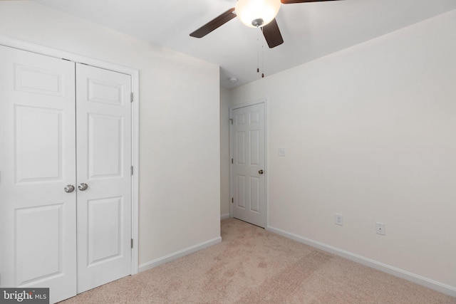 unfurnished bedroom with light carpet, a closet, and ceiling fan