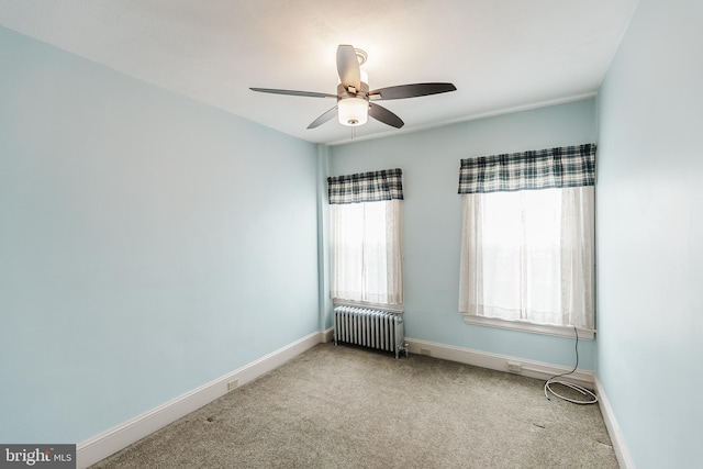 carpeted spare room with radiator heating unit and ceiling fan