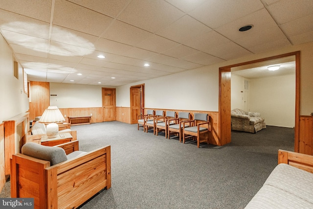 sitting room with a drop ceiling and dark colored carpet